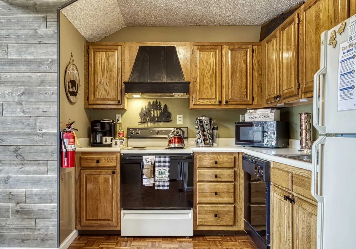 Another angle on the kitchen, showcasing wood cabinets, prominent kitchen appliances, and decorative wall art. The space feels inviting and functional, suggesting a place where both everyday meals and special gatherings are enjoyed.